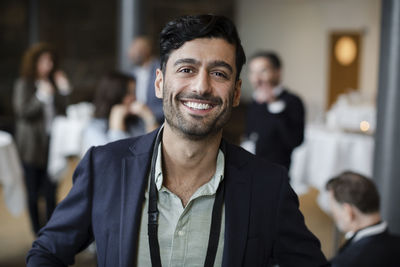 Portrait of confident businessman in blazer at seminar