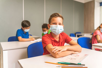 Portrait of smiling boy sitting at classroom