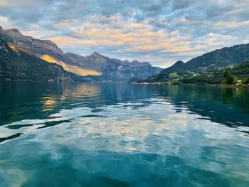 Scenic view of lake by mountains against sky