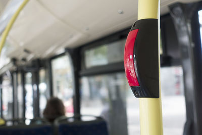 Close-up of red push button on pole in bus