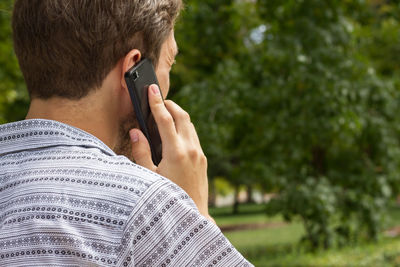 Rear view of man using mobile phone