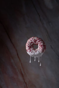 Copy space pink donut floating with white dips on marble background