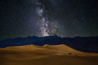 Scenic view of star field over desert landscape