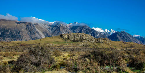 Scenic view of mountains against blue sky