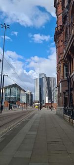 Street amidst buildings against sky in city