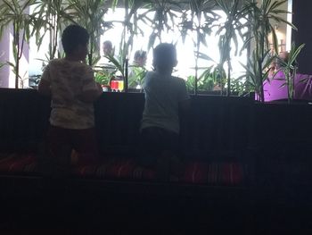 Rear view of couple sitting on window