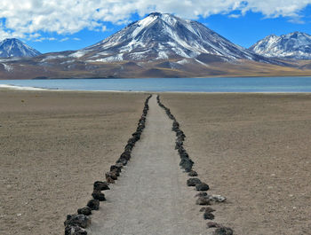 Road by lake against mountains