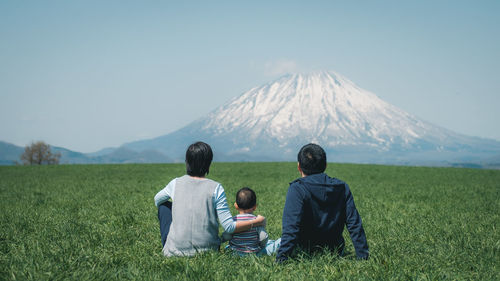 Rear view of couple sitting on land