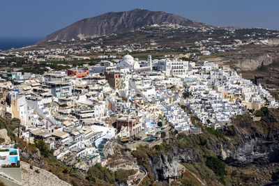 Aerial view of townscape and mountains during sunny day