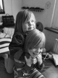 Portrait of a smiling girl sitting with her sister 