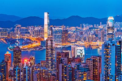 Illuminated modern buildings in city against sky