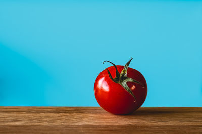 Close-up of strawberry on table against blue background