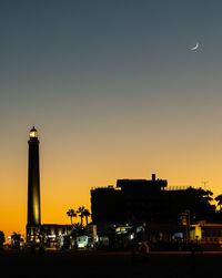 Silhouette buildings against sky at night