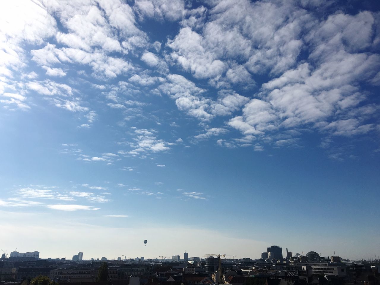 AERIAL VIEW OF CITYSCAPE AGAINST CLOUDY SKY