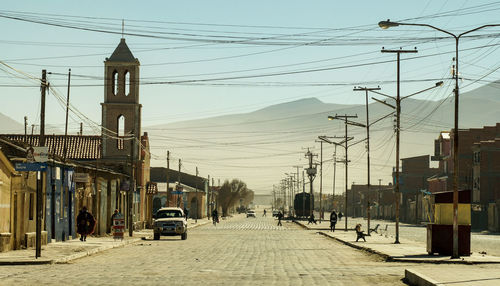 Cars on street in city against clear sky