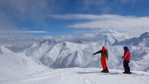 Rear view of tourists on snow covered mountain