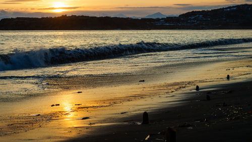 Scenic view of beach against sky during sunset