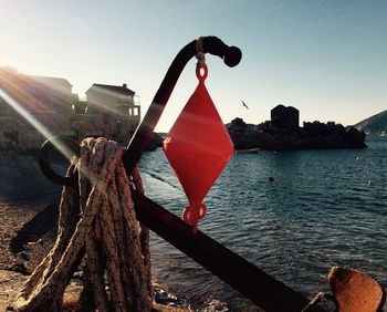 Close-up of red tied up by sea against clear sky