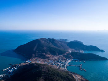 Scenic view of sea and mountains against clear blue sky