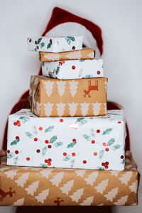 Young woman holding christmas gifts standing against white background