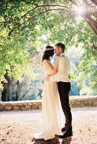 Side view of woman standing against trees