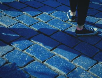 Low section of woman walking on footpath