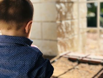 Rear view of boy standing outdoors