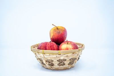 Close-up of apples in basket against white background