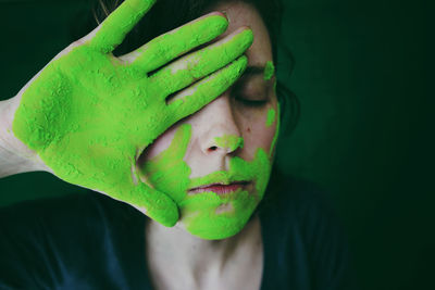 Close-up of woman gesturing with green hand