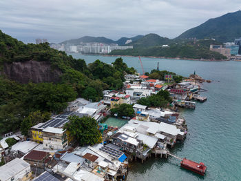 High angle view of townscape by sea against sky