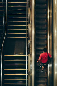 High angle view of man walking on escalator