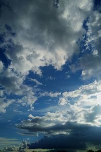 Low angle view of sunlight streaming through clouds