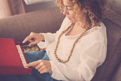 Woman playing small piano at home