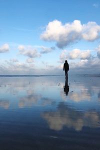 Silhouette man standing on beach against sky