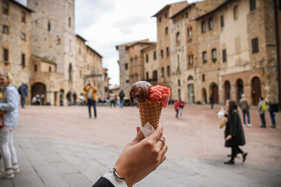 People holding ice cream in city
