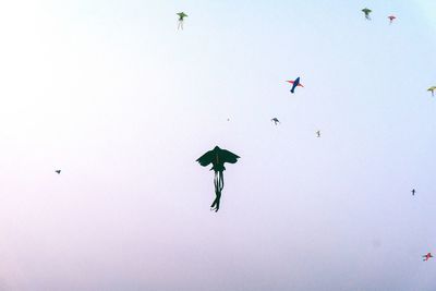 Low angle view of kites flying against clear sky