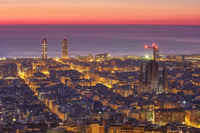 High angle view of illuminated cityscape against sky during sunset