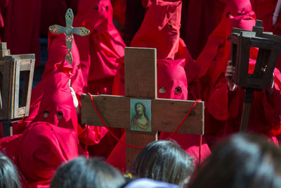 High angle view of penitentes holding cross while standing on street