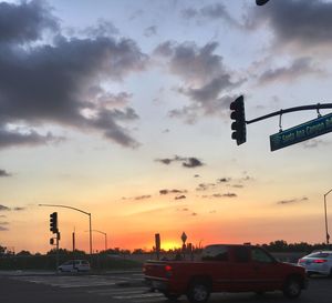 Cars on road against sky during sunset