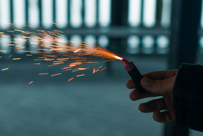 Cropped hand of woman holding sparkler