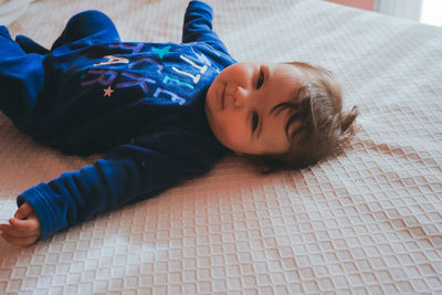 High angle view of boy resting on bed