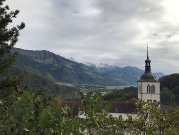 Scenic view of building and mountains against sky