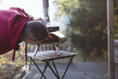 Man starting fire in outdoor pizza oven