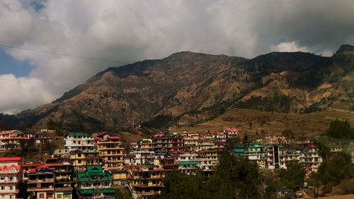 Town by mountain against sky