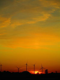 Silhouette of wind turbines at sunset