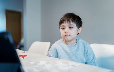 Portrait of boy sitting on table