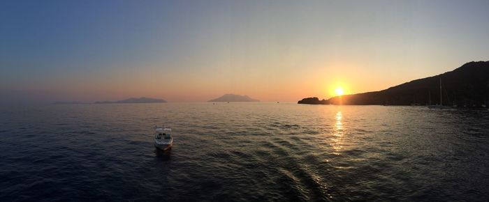 Rear view of people standing in sea against clear sky