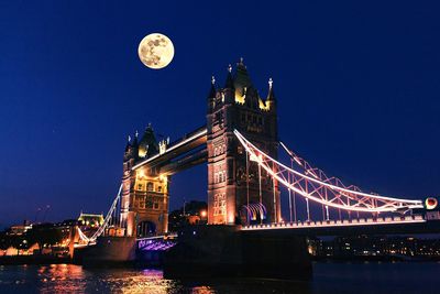 Low angle view of illuminated suspension bridge at night