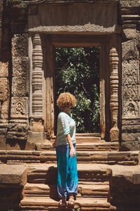 Side view of mid adult woman standing on steps in historic building