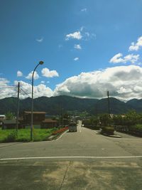 Road by trees against sky